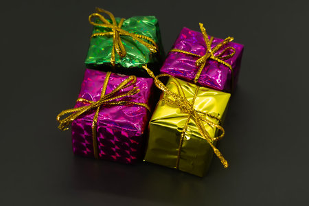 Wrapped colorful gifts on black background. Christmas, birthday, valentines day concept.