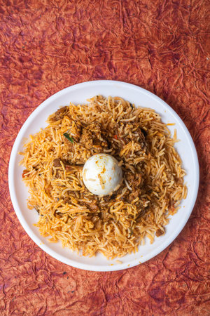 Indian Chicken Biryani dish is delicious and fragrant served on a white plate with egg in the middle top view.の写真素材