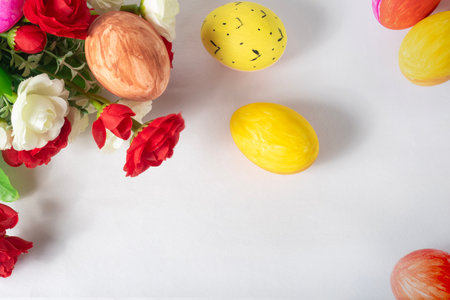 Easter eggs and spring rose flowers on white background. Happy Easter. Top viewの写真素材