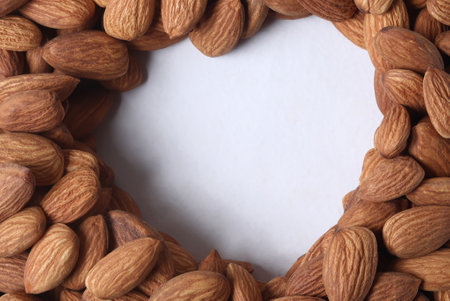 Closeup shot of Almonds with heart shaped blank space on white background. Top viewの写真素材