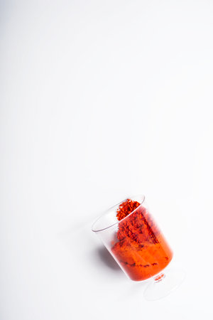Vertical shot of red holi powder in glass cup on white background. top viewの写真素材