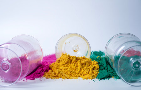 Pink, green, yellow three different color holi powder and glass jars on white background. Holi festivalの写真素材
