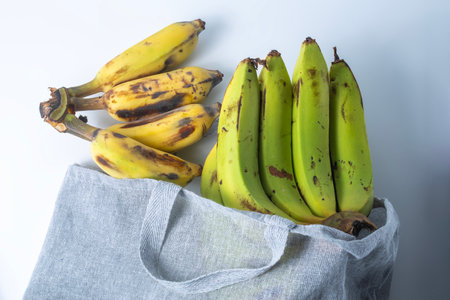 Bunch of bananas in a textile bag on a white background. Selective focus.の写真素材