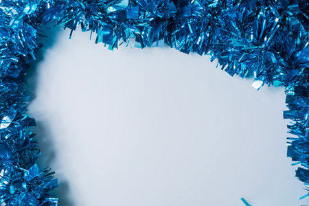 Blue tinsel on a white background with copy space for text. Concept of Christmas and New Year.の写真素材