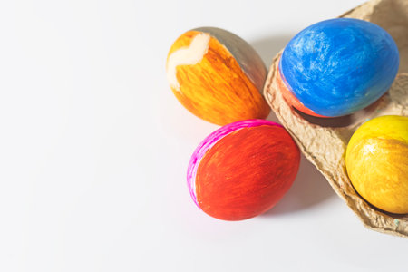 Colorful easter eggs in a cardboard box on a white background. Selective focusの写真素材