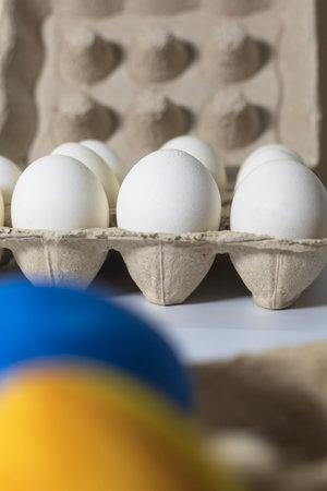 Eggs in a carton on a white background. Selective focus. Vertical shot