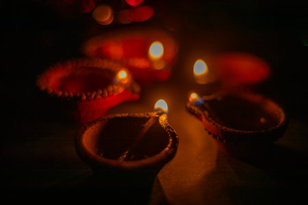 Glowing clay lamps during Indian festival Diwali celebrations on black background. Selective focusの写真素材