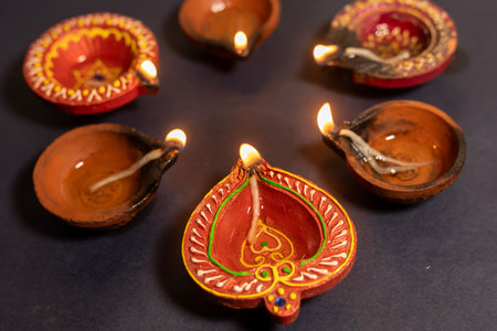 Happy Diwali - Beautiful diya lights lit during Diwali celebration on black background. Hindu traditional.の写真素材