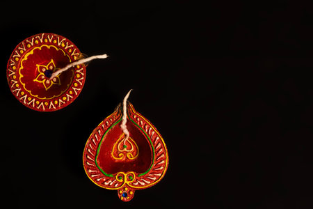 Happy Diwali - Top view of Diwali oil lamps on black background with space for text.の写真素材