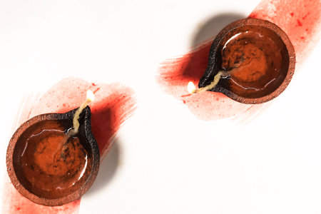 Hindu tradition Diwali diya oil lamps burning over paint stroke on white background. Copy space for text.の写真素材