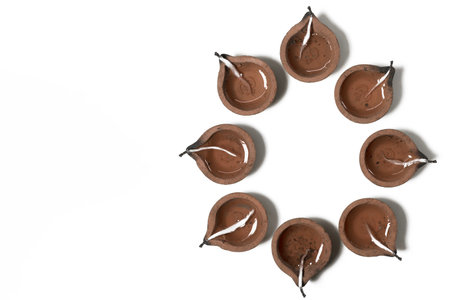 Hindu traditional clay diya arrangement for Diwali celebration on white background. It is used during Diwali, Karthigai Deepam and other Indian festivals.の写真素材