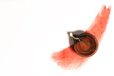 Hindu tradition Diwali diya oil lamps burning over paint stroke on white background. Copy space for text.の写真素材