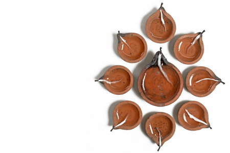 Hindu traditional clay diya arrangement for Diwali celebration on white background with copy space for text. It is used during Diwali, Karthigai Deepam and other Indian festivals.の写真素材