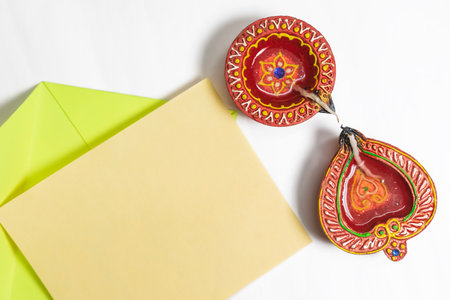 Diwali greeting card with festive diya lamp on white background.