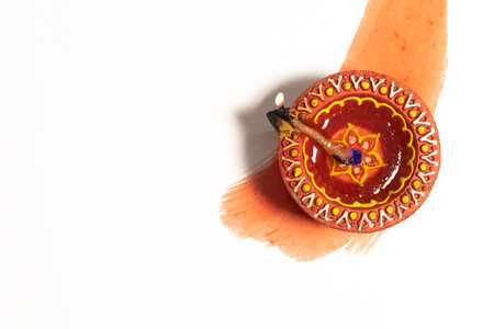 Hindu tradition Diwali diya oil lamps burning over paint stroke on white background. Copy space for text.の写真素材