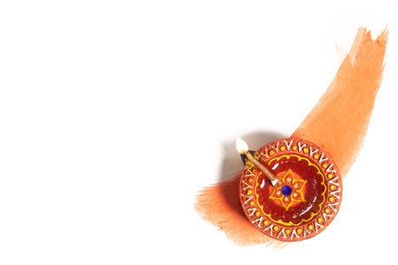 Hindu tradition Diwali diya oil lamps burning over paint stroke on white background. Copy space for text.の写真素材