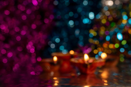 Glowing Diwali diyas with beautiful light reflection on the ground with bokeh effect in dark background. Selective focus.の写真素材