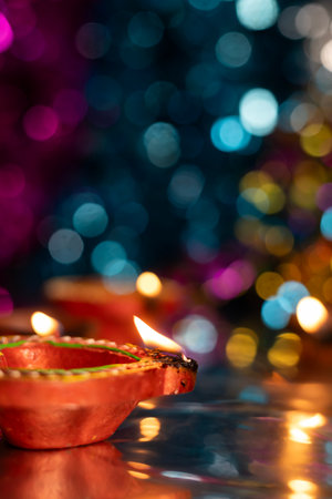 Diwali celebration background with glowing clay lamps and colorful lights. Selective focus.の写真素材