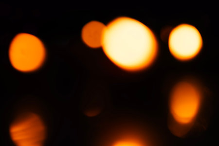 Abstract blurred warm bokeh lights against a dark background. bokeh effect on black background.の写真素材