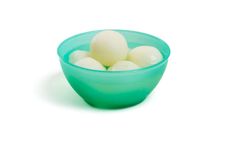 Traditional Indian rasgulla sweet in green plastic bowlの写真素材
