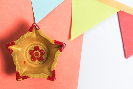Colorful Golden Star Diyas on orange paper with decorative flag for Diwali celebrationの写真素材