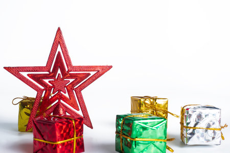 A red Christmas star ornament with colorful gift boxes on a clean white background. Ideal for holiday greetings, Christmas ads, and seasonal decorations.の写真素材