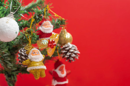 Vivid Christmas decorations displayed on a tree, featuring Santa ornaments and festive elements, against a red background.の写真素材