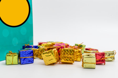 A delightful arrangement of colorful wrapped gifts paired with a fancy bag, perfect for celebratory occasions like holidays, birthdays, and festive events.の写真素材