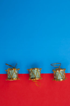 Three beautifully arranged traditional decorative drums set against a vibrant blue and red background, Perfect for holiday celebrations, cultural designs, and seasonal decorations.の写真素材