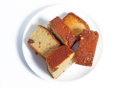 Delicious slices of homemade cake with nuts served on a white plate, showcasing a perfect treat for snacks.の写真素材