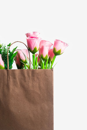 A beautiful bouquet of vibrant pink roses decorated in a rustic paper bag, perfect for celebrating special occasions and expressing love and affection.の写真素材