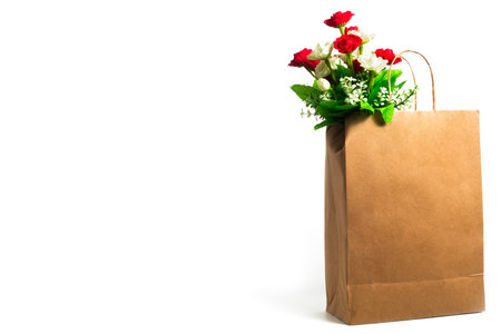 A beautiful bouquet of vibrant red and white roses in a paper bag, perfect for celebrating special occasions and expressing love and affection.の写真素材