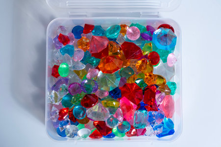 A vibrant assortment of colorful gemstones and crystals that sparkle under the light in a plastic...