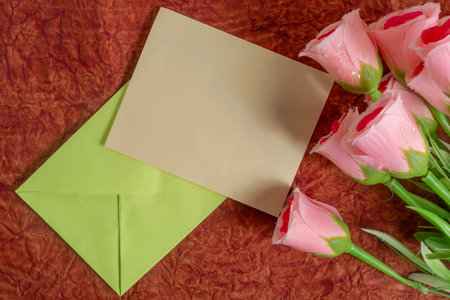 Pink roses and an empty envelope create a heartfelt setting ideal for expressing emotions.