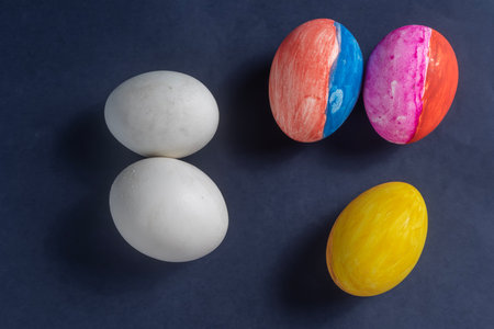 Collection of colorful and white eggs arranged on a dark blue background, representing creativity and Easter celebrations. Perfect for holiday, art, spring, and creative projects.の写真素材