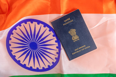 Indian passport placed over a vibrant Indian flag, showcasing cultural pride and identity.の写真素材