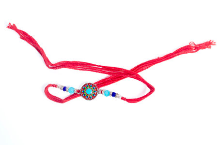 Adorned with colorful beads and intricate patterns, this artisan red thread bracelet also showcases...
