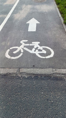 Bike path. Sign of track for cyclists. Narrow asphalt pavement. Abstract gray background Free focus. Bike path in Park. . Bike lane. Symbol of cycle paths on pavementの写真素材