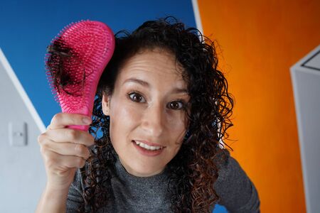 young woman teaches how to comb her hair through her hair