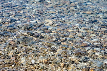 light and bright pebble stones into the water