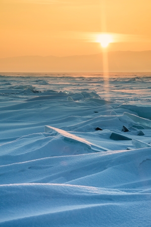 Field of ice hummocks on the frozen Lake Baikal. Sunsetの写真素材