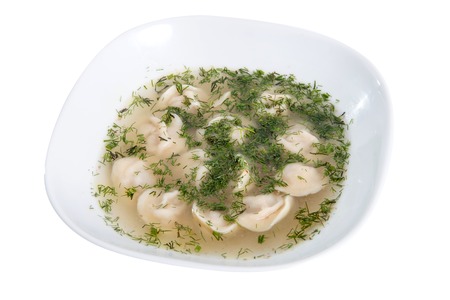 Dumplings and parsley with broth - russian pelmeni - italian ravioli on white plate isolatedの写真素材