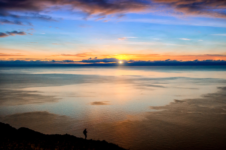 Beautiful red sunset over the lake with mountainの写真素材