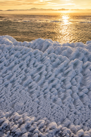 Ice floes floating on the fog water in the lake Baikal. Sunset