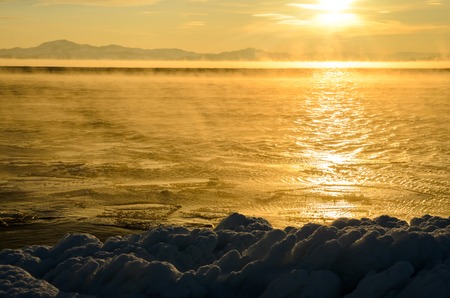 Ice floes floating on the fog water in the lake Baikal. Sunsetの写真素材
