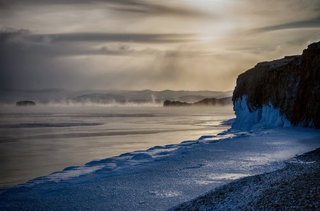 Field of ice hummocks and rock on the frozen Lake Baikal. Sunset. Russia