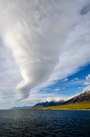 Mountains landscape - cloudy sky in pastel colors for your design. Romantic seascape - seaside view with silhouettes of blue hills in a fog and fall forestの写真素材