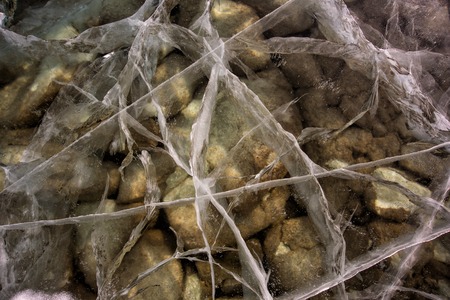 Baikal deep transparent ice cracked. At the pebbles bottom of Baikal lakeの写真素材