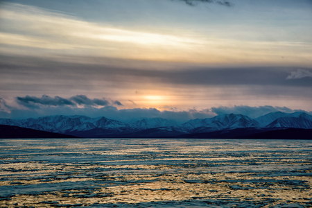 Sunset over frozen lake. Winter landscape of Mongolia.の写真素材