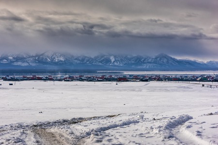 Winter village view. Snow covered mountains. Moubtains, buildings in Mongoliaの写真素材